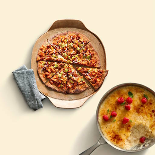 Pizza on stoneware, food cooked in a stainless steel pan