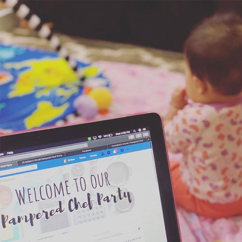 Consultant perspective working from a laptop and watching a baby