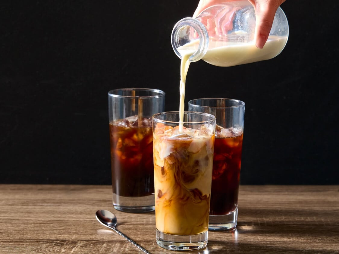 Pouring milk into iced coffee
