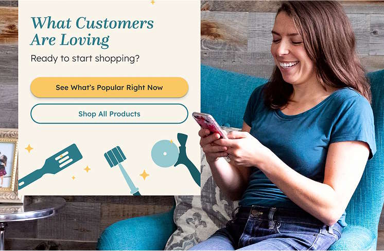A woman sitting on a chair, shopping Pampered Chef on her phone; with a pop-up display from the phone demonstrated in the background reading: what customers are loving. ready to start shopping? See what's popular right now or shop all products.