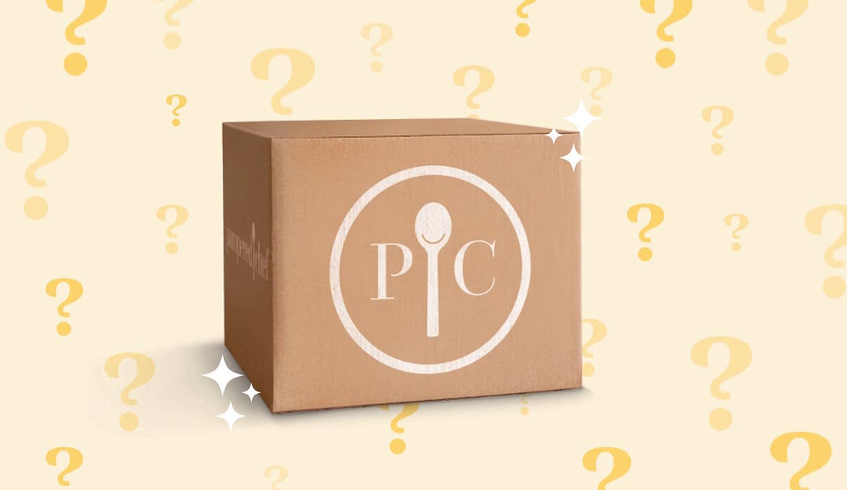 a mysterious looking box with the Pampered Chef logo on it, with some shiny sparkles up front and a question mark background.